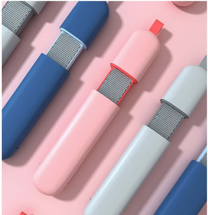 Double-sided electrostatic pet hair remover brushes in blue, pink, and white on a pink background.