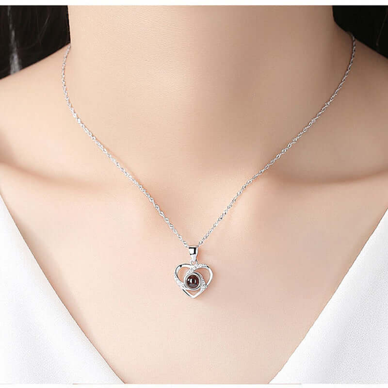 S925 silver heart shaped pendant necklace with colorful photo projection feature worn on a woman's neck.