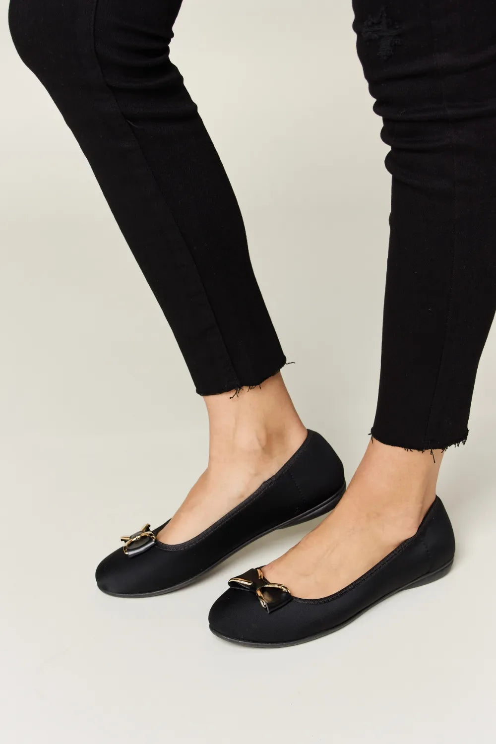 Black flats worn with black pants