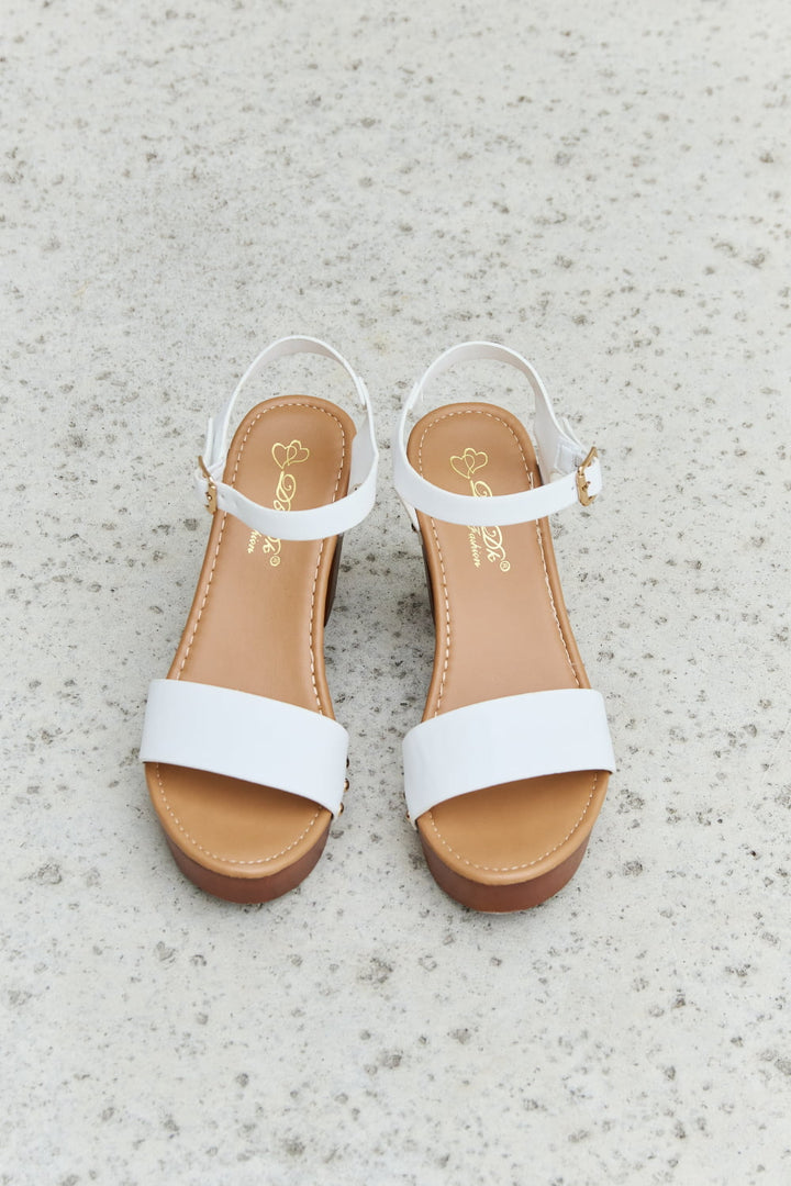 White sandals with tan soles