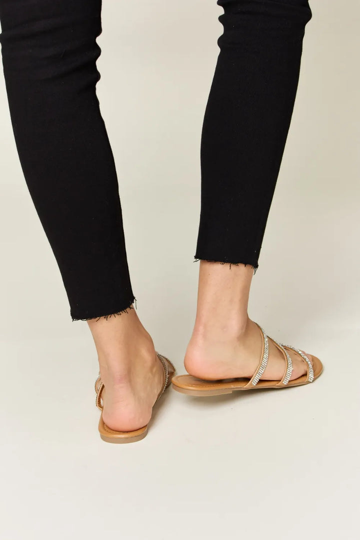 Person wearing black pants and tan sandals