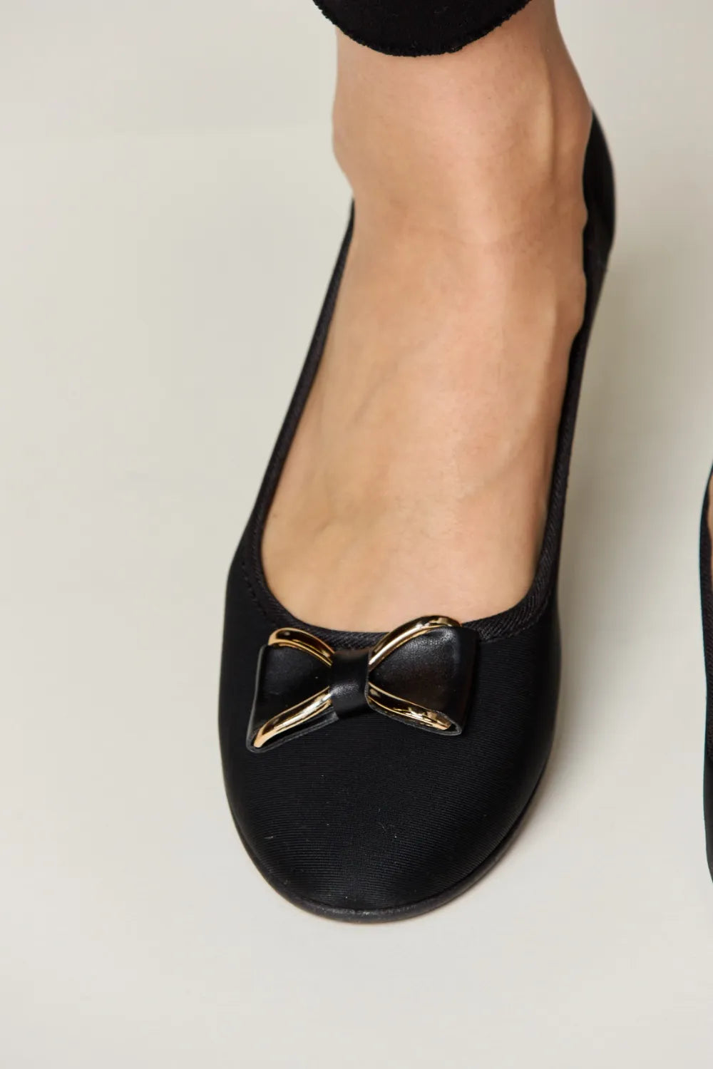 Black flat shoes with gold bow